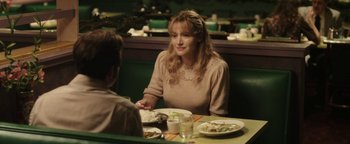 Movie still from “Labor Day” (2013), directed by Jason Reitman – A woman sitting at a table with a plate of food in front of her; Medium shot, Over the shoulder angle