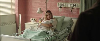 Movie still from “Labor Day” (2013), directed by Jason Reitman – A woman sitting in a hospital bed holding a baby; Medium shot, Over the shoulder angle