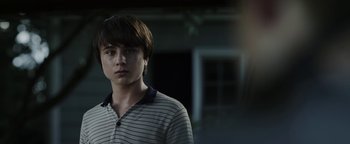Movie still from “Labor Day” (2013), directed by Jason Reitman – A young man standing in front of a building; Close Up shot, Over the shoulder angle