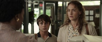 Movie still from “Labor Day” (2013), directed by Jason Reitman – Two people standing next to each other in front of a building; Close Up shot, Over the shoulder angle