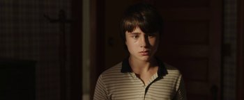 Movie still from “Labor Day” (2013), directed by Jason Reitman – A young man in a striped shirt looking at the camera; Close Up shot, Low angle