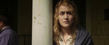 Movie still from “Labor Day” (2013), directed by Jason Reitman – A person with curly hair near a pillar; Close Up shot, Low angle