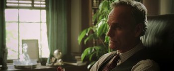 Movie still from “Labor Day” (2013), directed by Jason Reitman – An older man sitting in front of a green plant; Close Up shot, Over the shoulder angle