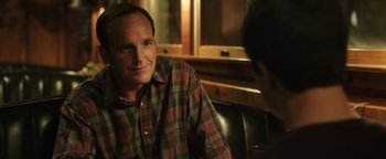 Movie still from “Labor Day” (2013), directed by Jason Reitman – A man sitting in front of another man in front of a window; Close Up shot, Over the shoulder angle