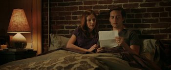 Movie still from “Labor Day” (2013), directed by Jason Reitman – A man and a woman sitting in a bed looking at a piece of paper; Medium shot, High angle