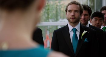 Movie still from “Laggies” (2014), directed by Lynn Shelton – A man wearing a suit and tie standing next to a woman; Close Up shot, Over the shoulder angle