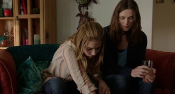 Movie still from “Laggies” (2014), directed by Lynn Shelton – Two young women sitting on a couch looking at something on a phone; Medium shot, Low angle