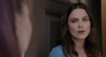 Movie still from “Laggies” (2014), directed by Lynn Shelton – A woman standing in front of a door looking at the camera; Close Up shot, Over the shoulder angle