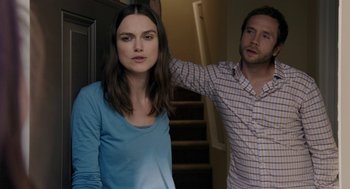 Movie still from “Laggies” (2014), directed by Lynn Shelton – A man and a woman standing next to each other in front of a staircase; Medium shot, Over the shoulder angle
