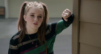 Movie still from “Laggies” (2014), directed by Lynn Shelton – A young woman leaning against a wall with her hand on the wall; Close Up shot, Over the shoulder angle
