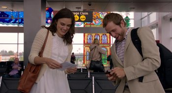 Movie still from “Laggies” (2014), directed by Lynn Shelton – A man and a woman looking at their cell phones at an airport; Medium shot, Low angle