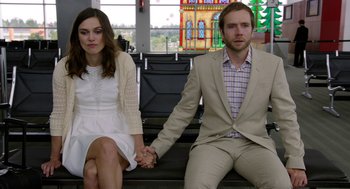 Movie still from “Laggies” (2014), directed by Lynn Shelton – A man and a woman holding hands while sitting on steps; Medium shot, Over the shoulder angle