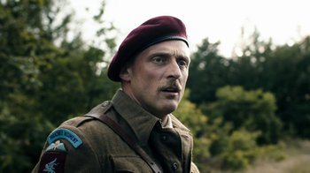 Movie still from “Land of Mine” (2015), directed by Martin Zandvliet – A man in a military uniform wearing a maroon hat; Close Up shot, Low angle