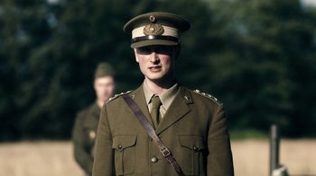 Movie still from “Land of Mine” (2015), directed by Martin Zandvliet – A man in a military uniform stands next to another man in a uniform; Medium shot, Low angle