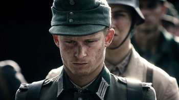 Movie still from “Land of Mine” (2015), directed by Martin Zandvliet – A man in a military uniform and a man in a helmet; Close Up shot, Low angle