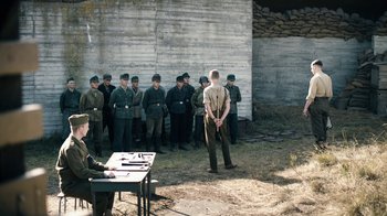 Movie still from “Land of Mine” (2015), directed by Martin Zandvliet – A group of men standing in front of each other; Wide shot, Over the shoulder angle