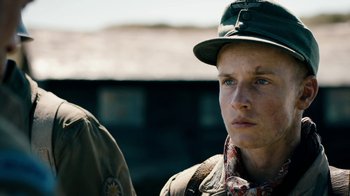 Movie still from “Land of Mine” (2015), directed by Martin Zandvliet – A man wearing a hat and a jacket; Close Up shot, Over the shoulder angle
