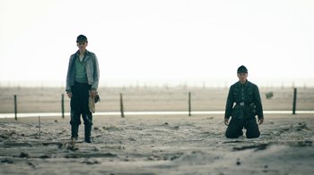 Movie still from “Land of Mine” (2015), directed by Martin Zandvliet – Two men in uniform standing in the sand; Wide shot, Low angle