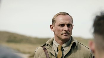 Movie still from “Land of Mine” (2015), directed by Martin Zandvliet – A person wearing a jacket and a tie; Close Up shot, Low angle