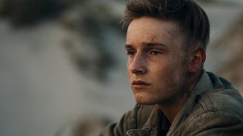 Movie still from “Land of Mine” (2015), directed by Martin Zandvliet – A young man with dirt all over his face; Close Up shot, Over the shoulder angle