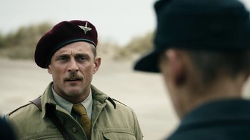 Movie still from “Land of Mine” (2015), directed by Martin Zandvliet – A man in a military uniform talking to another man in a hat; Close Up shot, Over the shoulder angle