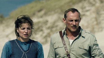 Movie still from “Land of Mine” (2015), directed by Martin Zandvliet – A man and a woman standing next to each other on a beach; Close Up shot, Over the shoulder angle