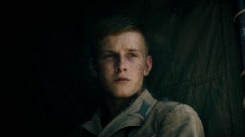 Movie still from “Land of Mine” (2015), directed by Martin Zandvliet – A young man in a military uniform looking at the camera; Close Up shot, Low angle