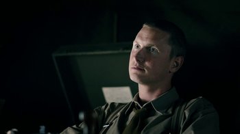 Movie still from “Land of Mine” (2015), directed by Martin Zandvliet – A man sitting in a chair looking into the distance; Close Up shot, High angle