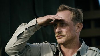 Movie still from “Land of Mine” (2015), directed by Martin Zandvliet – A person with a beard and mustache; Close Up shot, Low angle