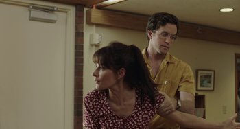 Movie still from “Language Arts” (2020), directed by Cornelia Duryée – A man and a woman are combing each other's hair; Medium shot, Over the shoulder angle