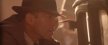 Movie still from “Last Man Standing” (1996), directed by Walter Hill – A person wearing a hat and glasses; Close Up shot, Over the shoulder angle