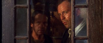 Movie still from “Last Man Standing” (1996), directed by Walter Hill – Two men standing next to each other in front of a window; Close Up shot, Low angle