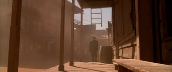 Movie still from “Last Man Standing” (1996), directed by Walter Hill – A man is walking down the street with a hat on; Wide shot, Low angle