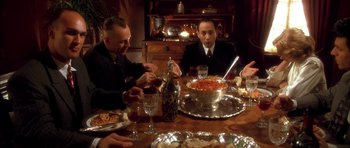 Movie still from “Last Man Standing” (1996), directed by Walter Hill – A group of people sitting around a table with food; Medium shot, High angle