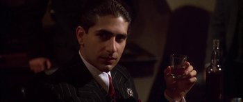 Movie still from “Last Man Standing” (1996), directed by Walter Hill – A man in a suit and tie holding a cigarette; Close Up shot, Low angle
