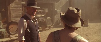 Movie still from “Last Man Standing” (1996), directed by Walter Hill – A man and a woman wearing hats and suits; Medium shot, Over the shoulder angle