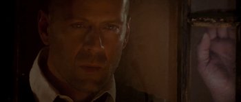 Movie still from “Last Man Standing” (1996), directed by Walter Hill – A person's face in a dark room; Close Up shot, Low angle