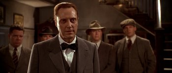 Movie still from “Last Man Standing” (1996), directed by Walter Hill – A person wearing a suit and tie; Medium shot, Low angle