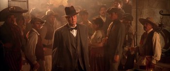 Movie still from “Last Man Standing” (1996), directed by Walter Hill – A man in a suit and hat in front of a group of people; Medium shot, Low angle