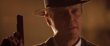 Movie still from “Last Man Standing” (1996), directed by Walter Hill – An older man wearing a hat and a suit; Close Up shot, Over the shoulder angle