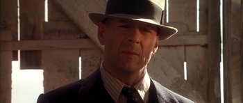 Movie still from “Last Man Standing” (1996), directed by Walter Hill – A man wearing a suit and a hat; Close Up shot, Low angle