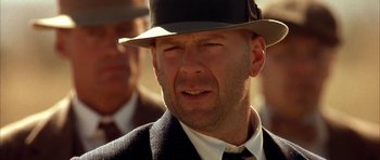 Movie still from “Last Man Standing” (1996), directed by Walter Hill – A man in a suit and a hat; Close Up shot, Low angle