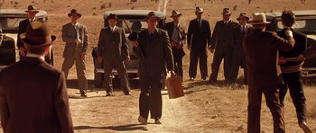 Movie still from “Last Man Standing” (1996), directed by Walter Hill – A group of men standing next to each other on a dirt road; Wide shot, Low angle