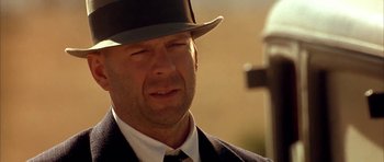 Movie still from “Last Man Standing” (1996), directed by Walter Hill – A person wearing a suit and a hat; Close Up shot, Low angle