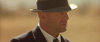 Movie still from “Last Man Standing” (1996), directed by Walter Hill – A person wearing a hat and a suit; Close Up shot, Low angle