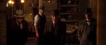 Movie still from “Last Man Standing” (1996), directed by Walter Hill – A man in a suit and hat standing next to another man in a hat; Medium shot, Low angle