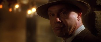 Movie still from “Last Man Standing” (1996), directed by Walter Hill – A person wearing a hat with lights in the background; Close Up shot, Low angle