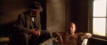 Movie still from “Last Man Standing” (1996), directed by Walter Hill – A man sitting next to another man in a bath tub; Medium shot, Low angle