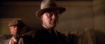 Movie still from “Last Man Standing” (1996), directed by Walter Hill – A person wearing a suit and a hat; Close Up shot, Low angle