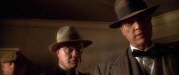 Movie still from “Last Man Standing” (1996), directed by Walter Hill – A man in a suit and a man in a hat; Close Up shot, Low angle